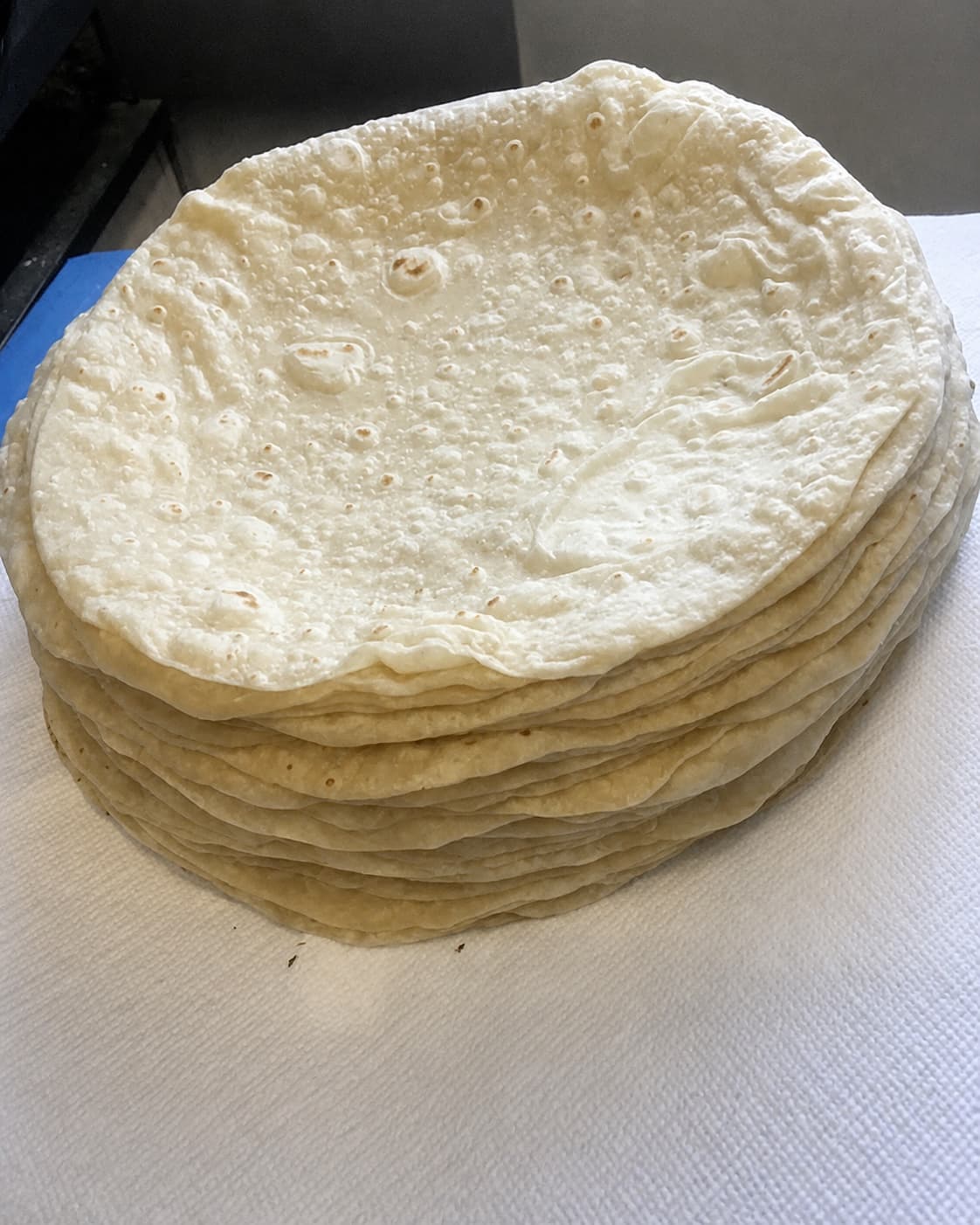 Stack of fresh homemade flour tortillas on paper towels