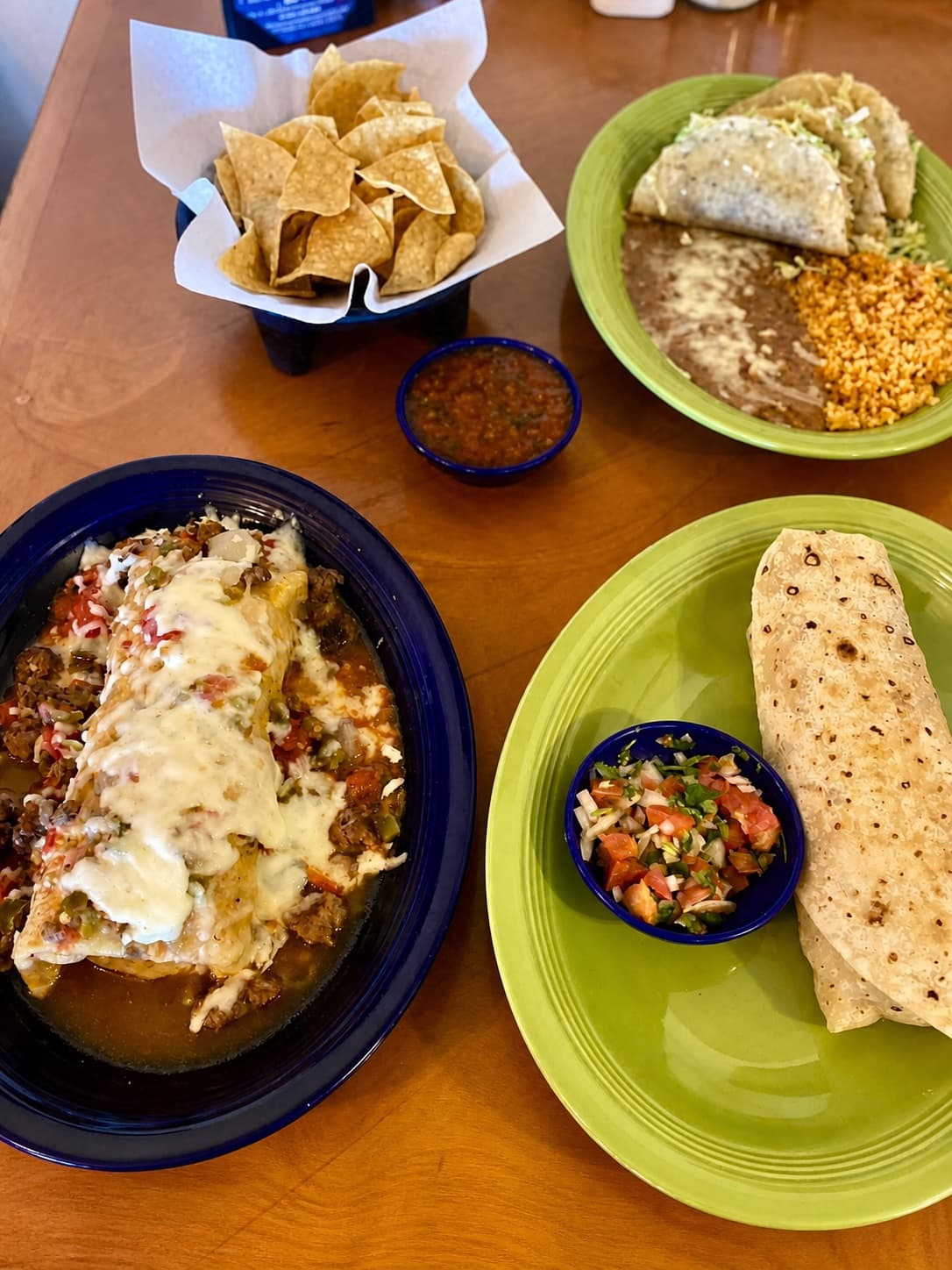 Green Saddle burrito, crispy tacos, chips, salsa, rice, and beans