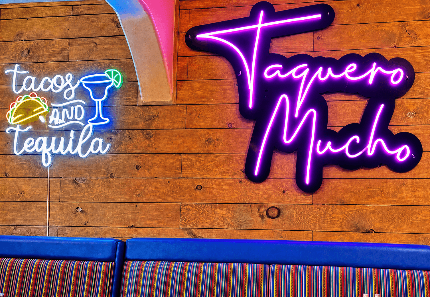 Tacos and tequila and Taquero Mucho neon signs inside El Charro
